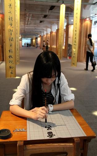9月4日,一名参观者在“汉字艺术节”上练习毛笔书法。新华社记者 樊浩宇 摄 “第四届两岸汉字艺术节”在台北举行